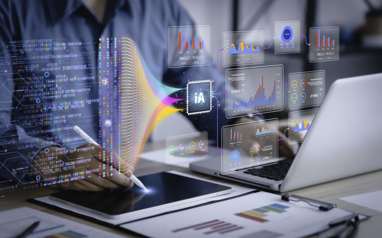 The image shows a person using a laptop with data dashboards and a tablet connected to an AI system. Holographic screens display graphs and charts, highlighting a data-driven workspace with integrated AI.